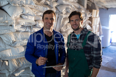 Portrait of coworkers standing by barley scaks