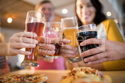 Low angle view of happy friends toasting drinks in restaurant