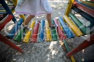 Low section of girl walking on jungle gym