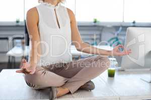 Female executives doing yoga in office