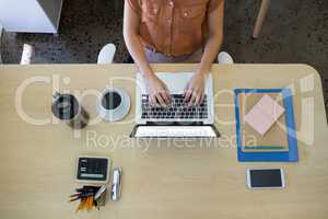 Female executive working over laptop at her desk
