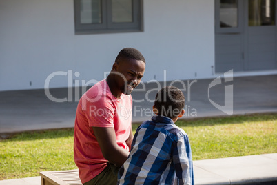 Father and son sitting in the backyard