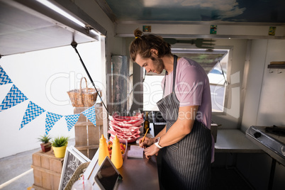 Waiter writing in notepad