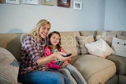 Mother and daughter watching television in the living room