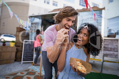 Happy woman feeding snacks to man