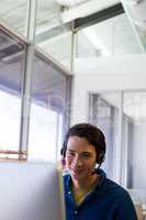 Male executive in headset working over computer at his desk