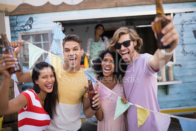 Happy friends holding beer bottles