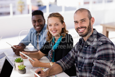 Happy executives using digital table in conference room