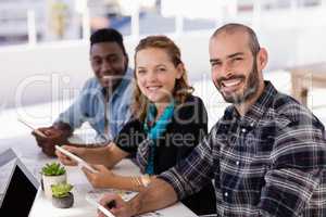 Happy executives using digital table in conference room