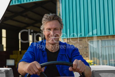 Smiling worker driving a tractor