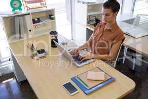 Female executive working over laptop at her desk