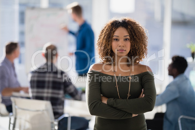 Female executive standing with arms crossed in the office