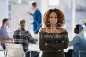 Female executive standing with arms crossed in the office