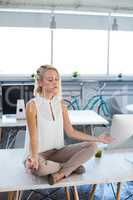 Female executives doing yoga in office