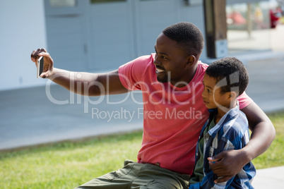 Father and son taking selfie on mobile phone