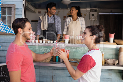 Couple toasting a glasses of juice at counter