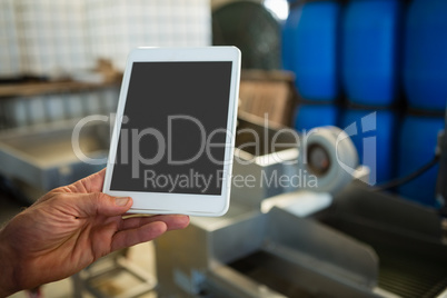 Hand of worker holding digital tablet