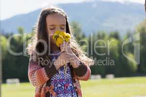 Cute girl smelling fresh flowers