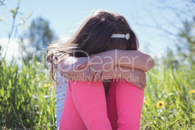 Sad girl sitting in parkland