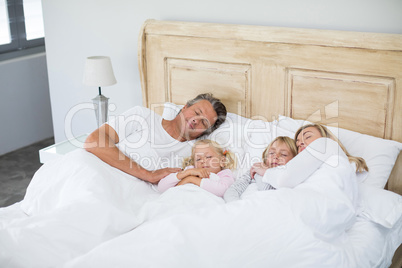 Family sleeping on bed in the bed room