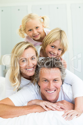 Happy family having fun on bed in the bed room