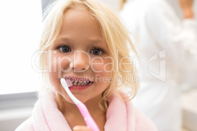 Girl brushing teeth in bathroom