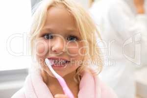 Girl brushing teeth in bathroom