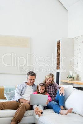 Family using laptop together in living room