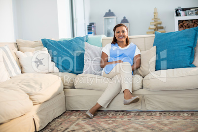 Smiling woman relaxing on sofa in living room