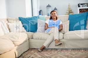 Smiling woman relaxing on sofa in living room