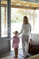 Mother and daughter standing together at home