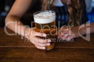 Midsection of barmaid with beer glass