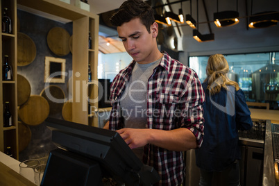 Man using cash register at bar