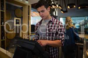 Man using cash register at bar