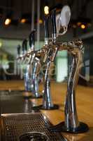 Beer taps in row at bar