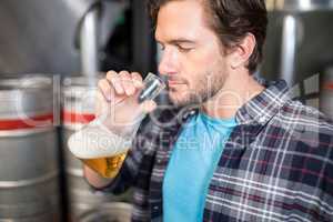 Man examining beer in beaker