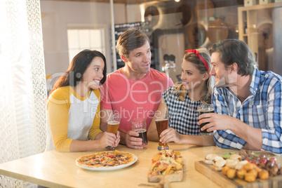 Friends talking while having beer in restaurant