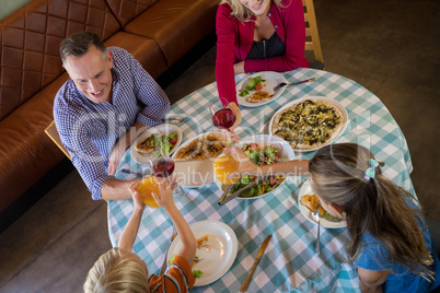 Family toasting drinks while dining at restaurant