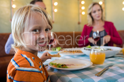 Portrait of boy dining with family