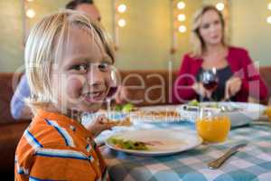 Portrait of boy dining with family