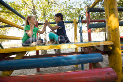 Low angle view of girls playing clapping game on jungle gym