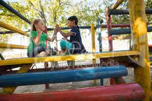Low angle view of girls playing clapping game on jungle gym