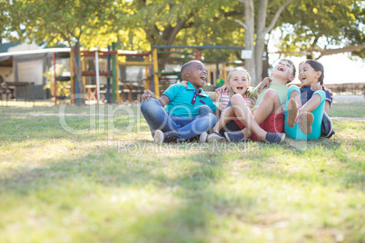 Cheerful children with arms around sitting at park