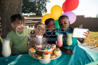 Boy taking selfie with friends at park