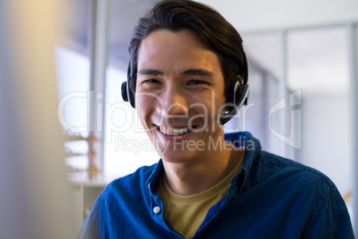 Male executive in headset at his desk in office