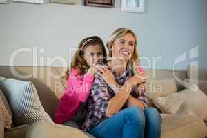 Mother and daughter embracing each other in the living room