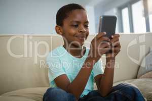 Boy using mobile phone in the living room