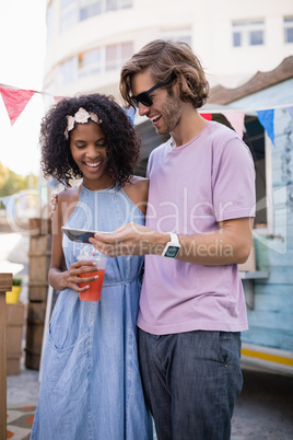 Happy couple using mobile phone