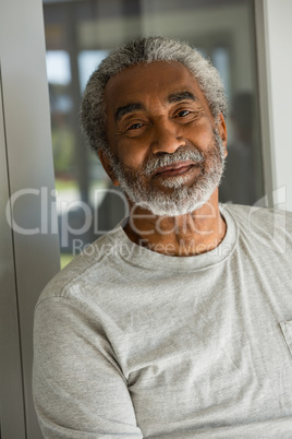 Senior man standing at the entrance of house