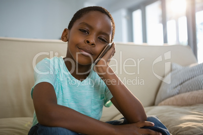 Boy talking on mobile phone in the living room at home